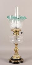 A VICTORIAN BRASS OIL LAMP, having an etched and turquoise frilled shade, with a glass reservoir