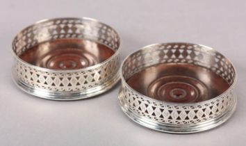 A PAIR OF GEORGE III SILVER COASTERS, London 1786 for Robert Hennell, having a beaded rim and