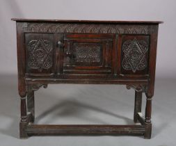 AN OAK CUPBOARD OF 17TH CENTURY STYLE, of narrow proportions, gouge cut ends to the top, above a