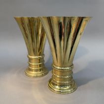 A PAIR OF 19TH CENTURY BRASS VASES OF FLATTENED FLUTED FORM ON AN ANNULATED CIRCULAR BASE AND