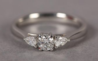A DIAMOND RING IN PLATINUM claw set to the centre with a brilliant cut stone, flanked by two pear