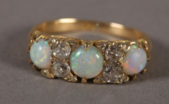 AN EDWARD VII OPAL AND DIAMOND RING in 18ct gold, the graduated circular cabochon opals claw set