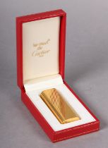 CARTIER MUST DE CARTIER CIGARETTE LIGHTER, in gold plaque horizontal gadroon case oval section and