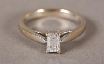 A SINGLE STONE DIAMOND RING in 18ct white gold, the step cut stone claw set flanked by tapered