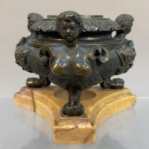 A 19TH CENTURY GRAND TOUR BRONZE INKWELL of circular compressed form cast with face masks and