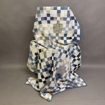 An American patchwork quilt in blues and creams stitched with striped, checked, spotted and floral