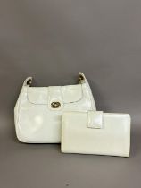 A white leather shoulder bag by Henrys of London with gold metal hardware, having a front flap