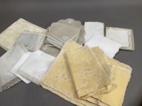 A quantity of table linens including a set of eight pale yellow damask napkins, sets of place mats