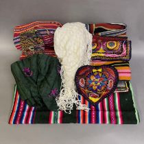 A Bolivian carrying cloth striped in reds pinks and blues, a green carrying cloth with felt