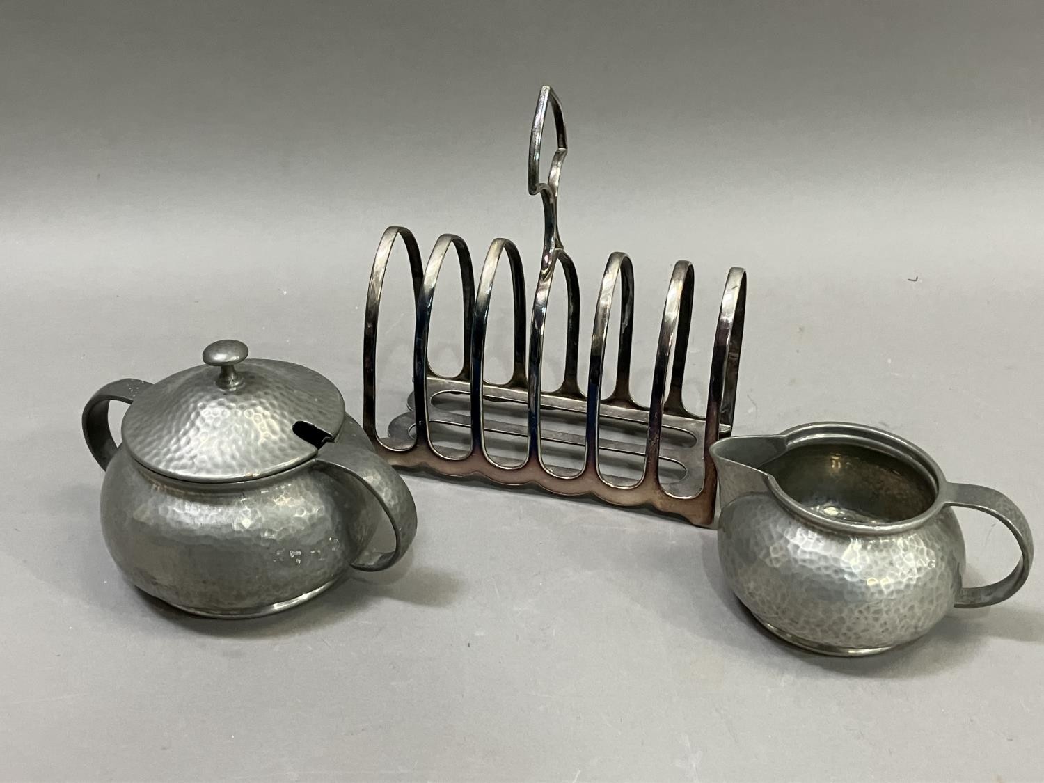 A silver plated seven bar toast rack together with a Tudric pewter cream jug and two handled