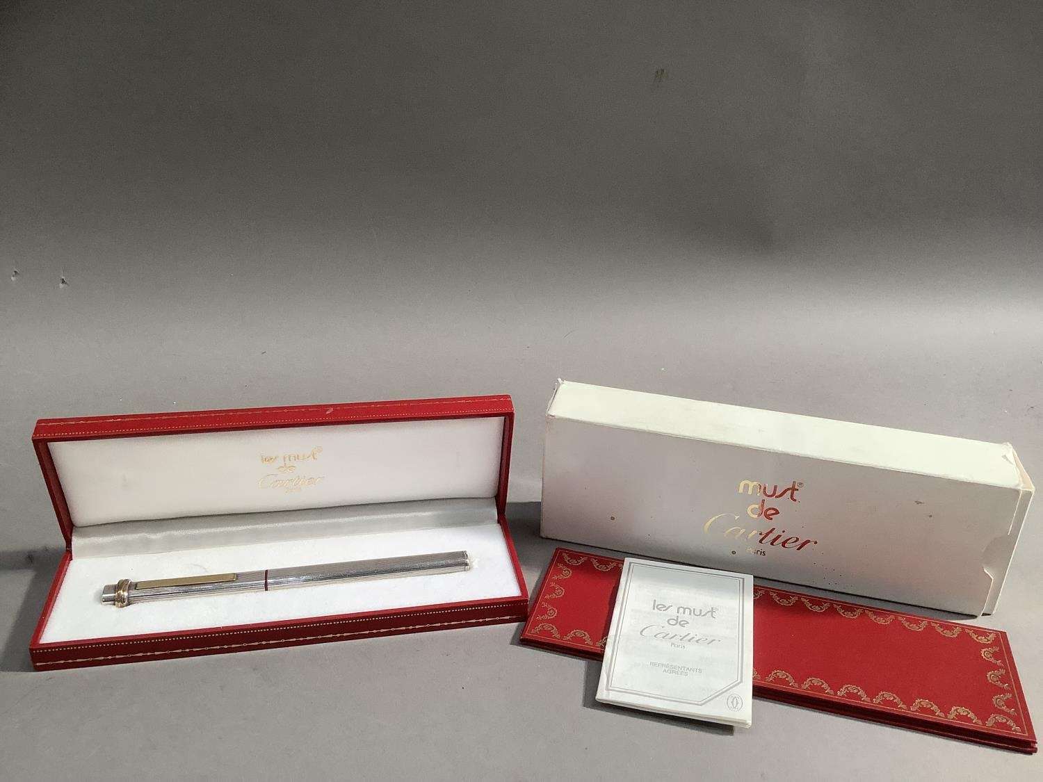 A Le Must de Cartier ball point pen with 18ct gold nib, in case with outer sleeve; together with