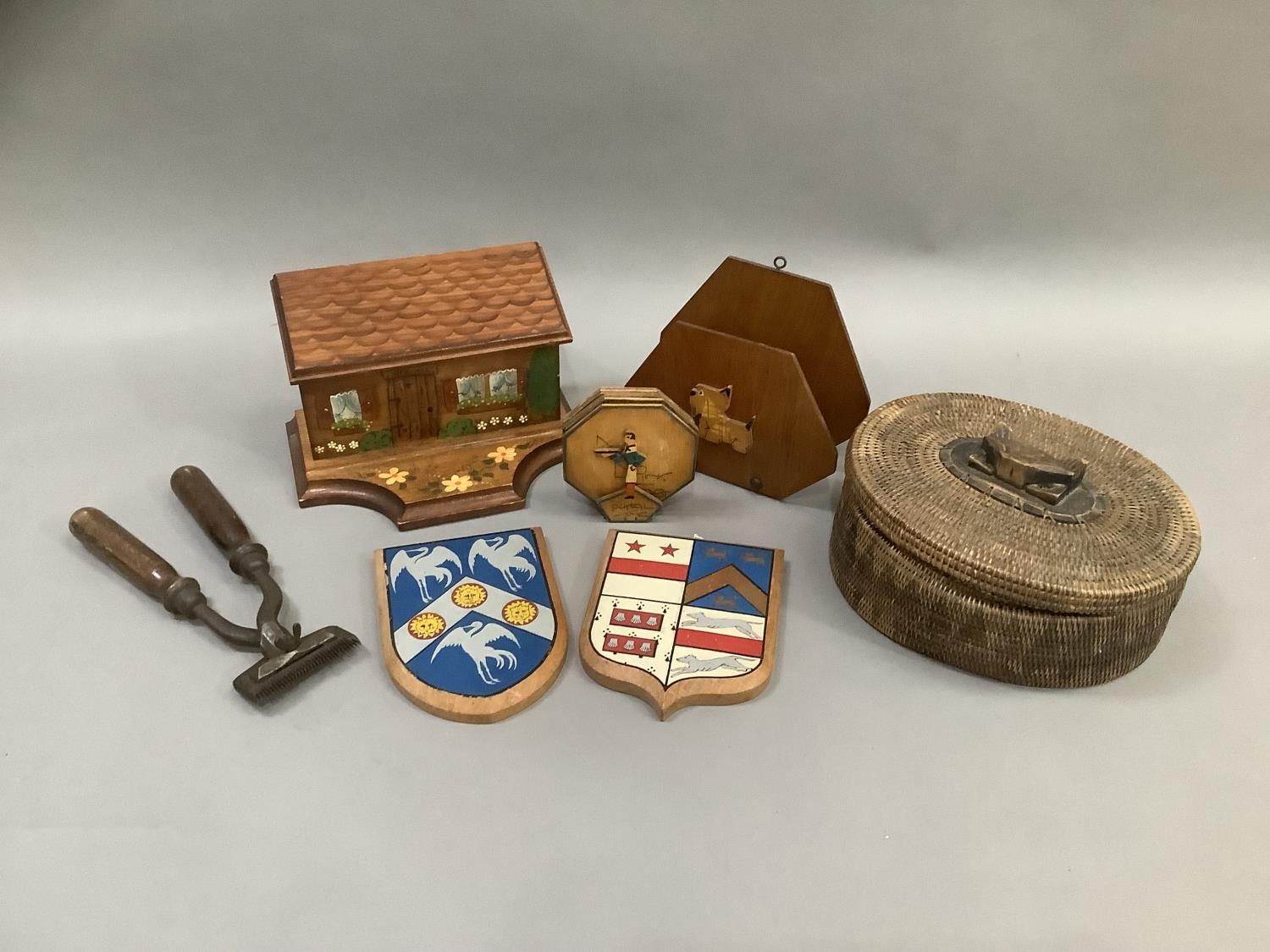 A wooden letterbox with pen slide in the form of a house, a pair of painted shields, a set of