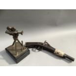 A flintlock pistol with animal pelt strap together with a bronze trophy