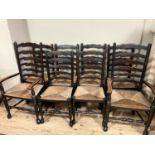 A set of eight early 20th century ladder back and rush seated dining chairs comprising two carvers