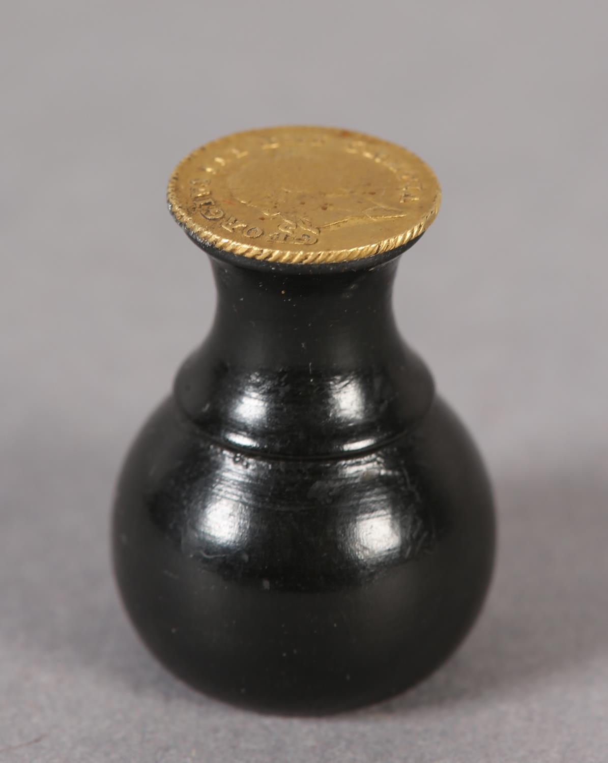 An ebony seal with a George III one-third Guinea Matrix (the coin c1797-1813), 3cm high (Shipping