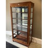 A Chinese teak and glazed display cabinet of five shelves with side opening doors, 191cm wide x