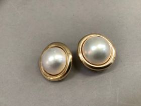 A pair of Mabé pearl earrings (at fault) each set with a 19mm pearl within a domed circular bezel,