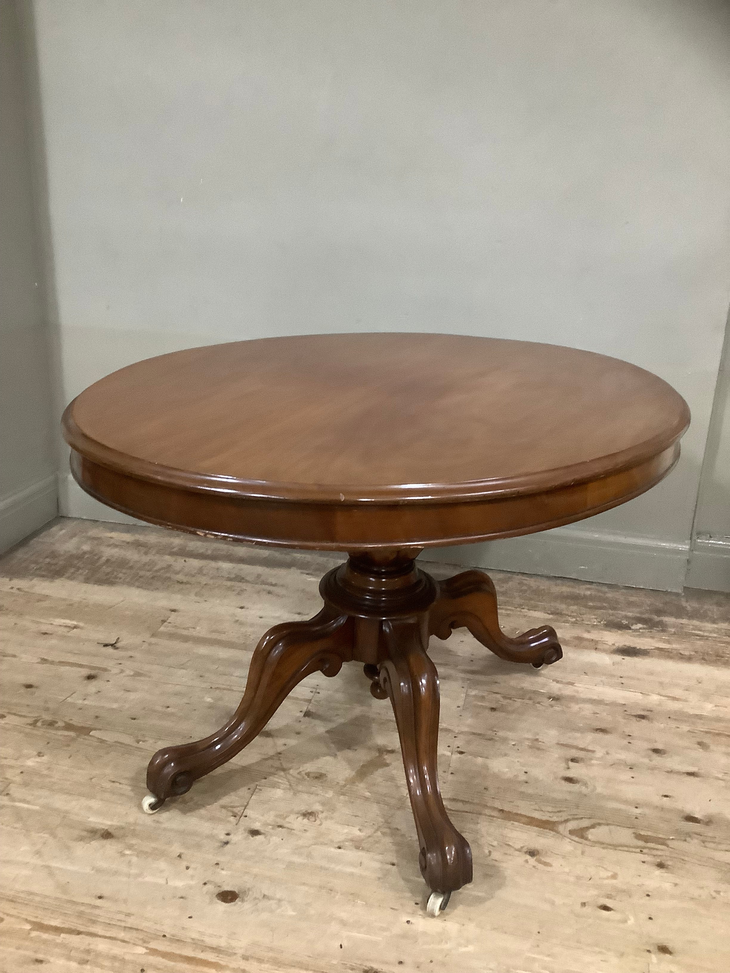 A mahogany Victorian oval Looe table on carved baluster column on four moulded cabriole legs with