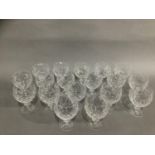 A set of eighteen cut glass red wine glasses