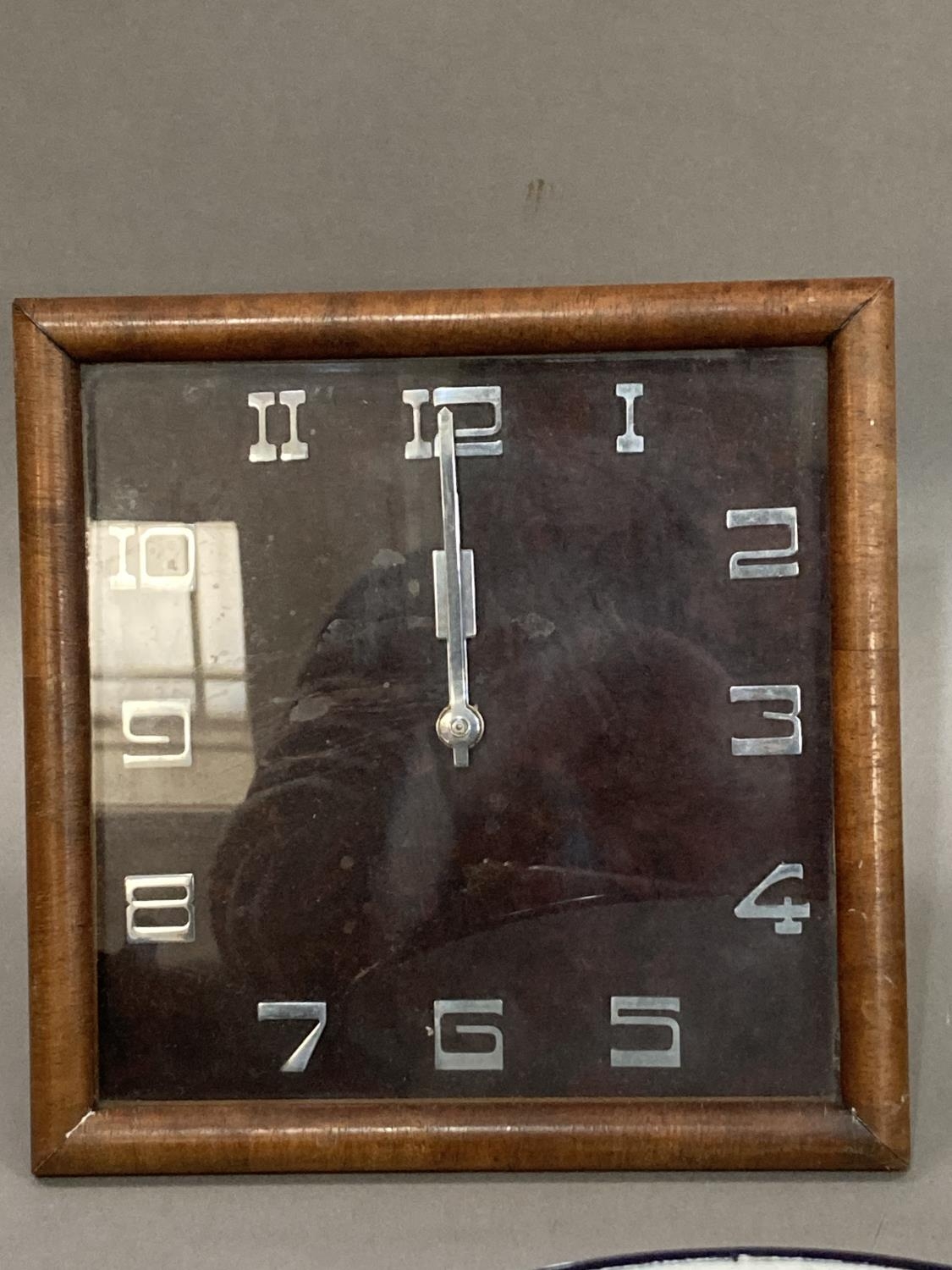 An Art Deco walnut mantle clock of square outline with chrome Arabic numerals and hands, with back