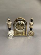 A domed brass and birdseye maple mantel clock with exposed movement, silvered chaptering with