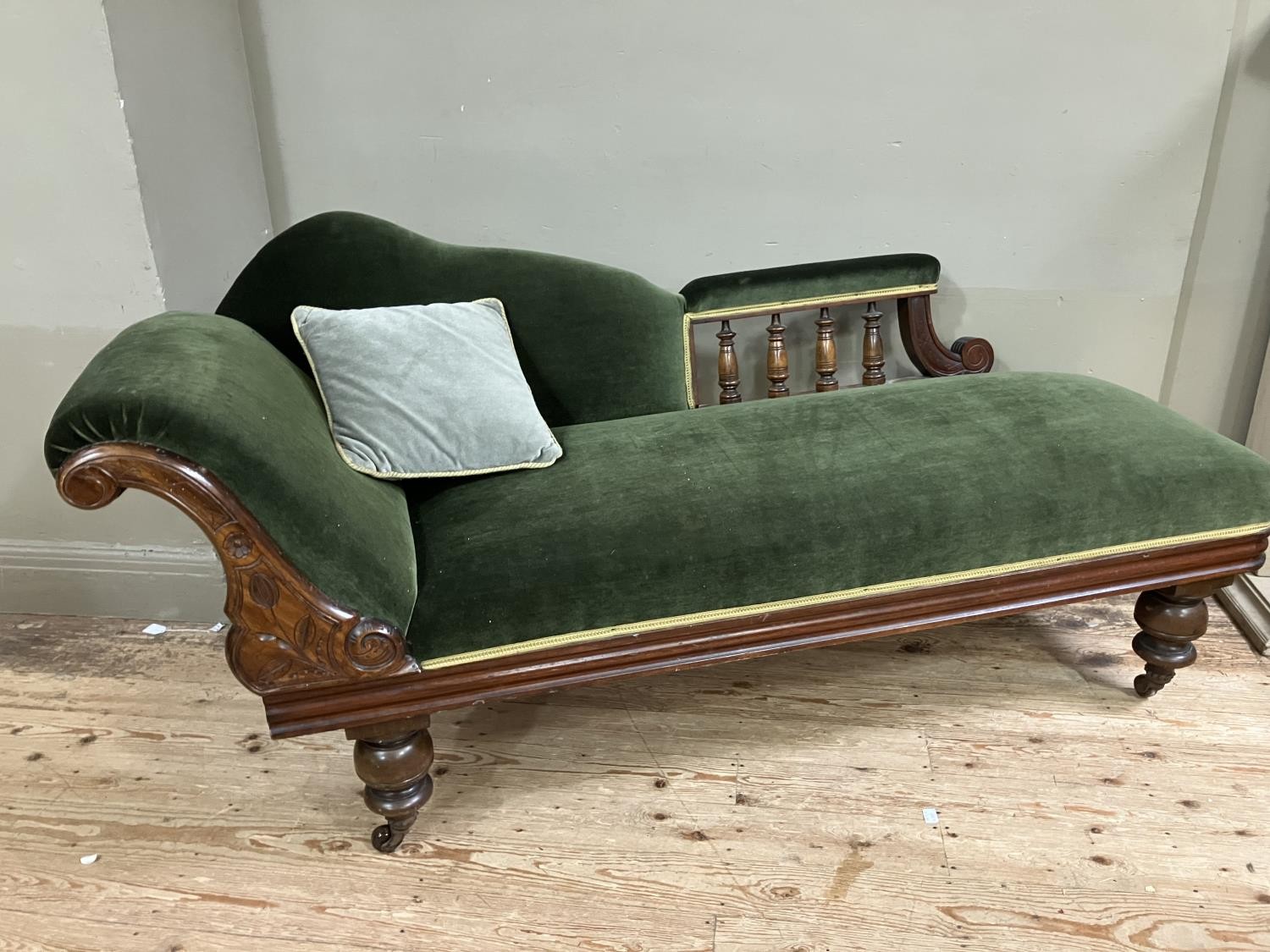 A Victorian walnut chaise longue upholstered in green velvet and on turned legs