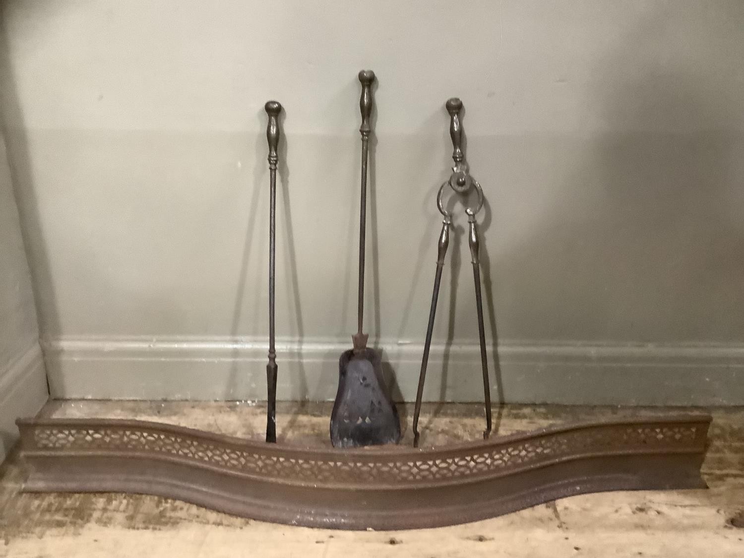 A set of 19th century steel fire irons and a steel curb of serpentine outline and pierced