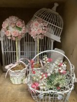 A white wire work bird cage, a composite white bust on marble base, two faux rose bushes in pots
