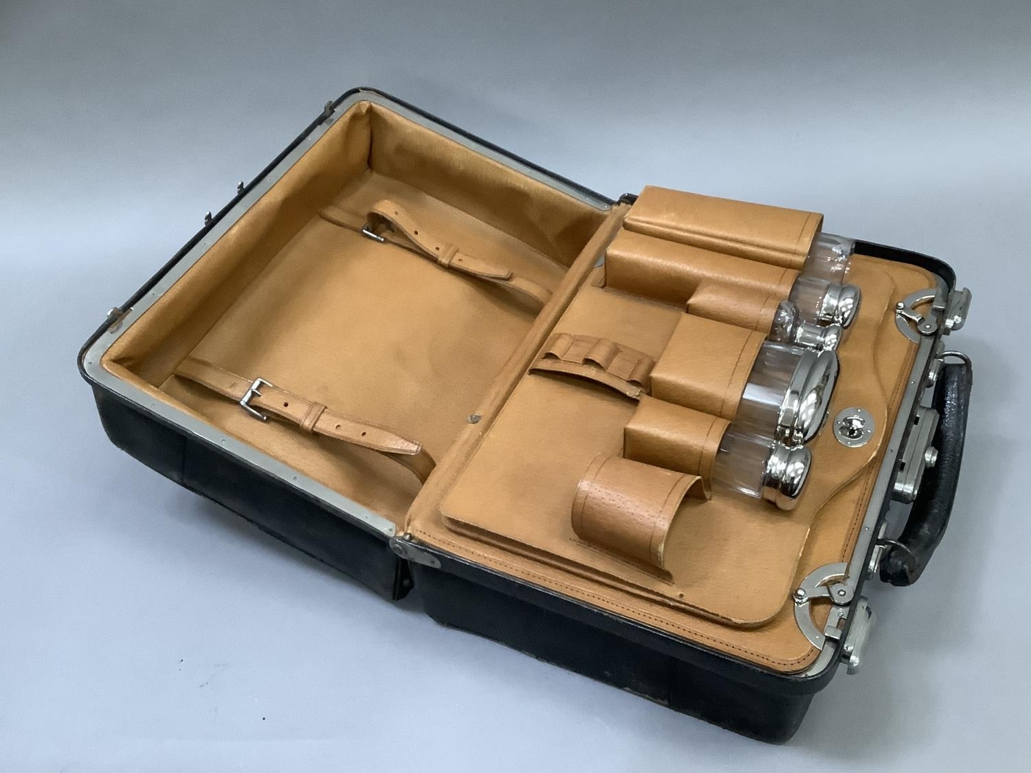 A gentleman's black Gladstone dressing case, interior lined with pig skin and fitted with various