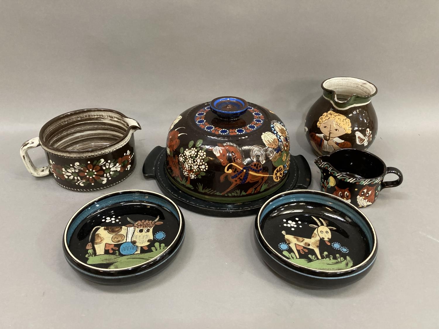 A collection of Swiss folk art pottery comprising, a cheese bell and dish by Daniel Stahli, Kholer