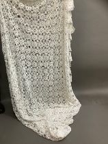 A large white crochet bed cover, with pierced central design and contrasting border, 220cm x 210cm