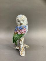 A Herend style china figure of an owl perched on a branch by Vista Alegre, Portugal, painted by hand