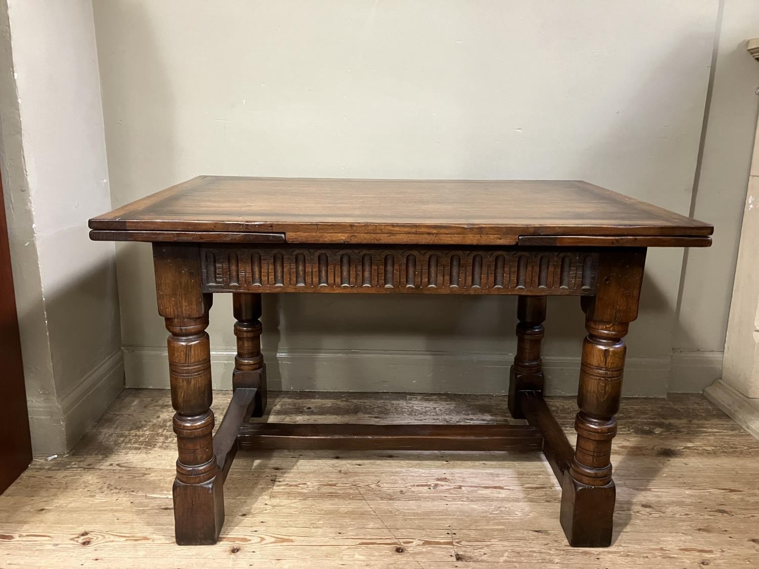 A Titchmarsh and Goodwin oak drawer leaf extending dining table on turned legs joined by an 'H' - Image 5 of 6