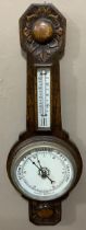 An early 20th century carved oak wheel barometer