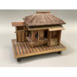 Model of a Japanese house raised on a platform and with bamboo feet. 23.5cm wide x 15.5cm deep x