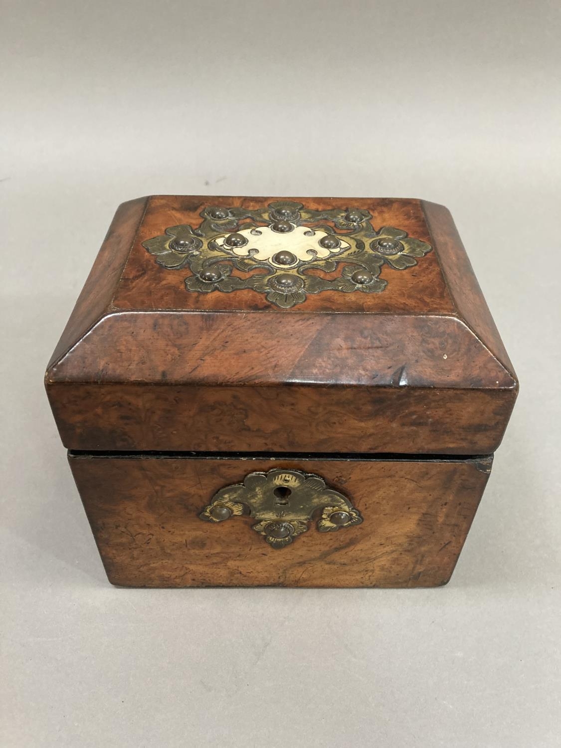A 19th century walnut tea caddy having cut gilded metal and ivory applied cartouche and gilt metal