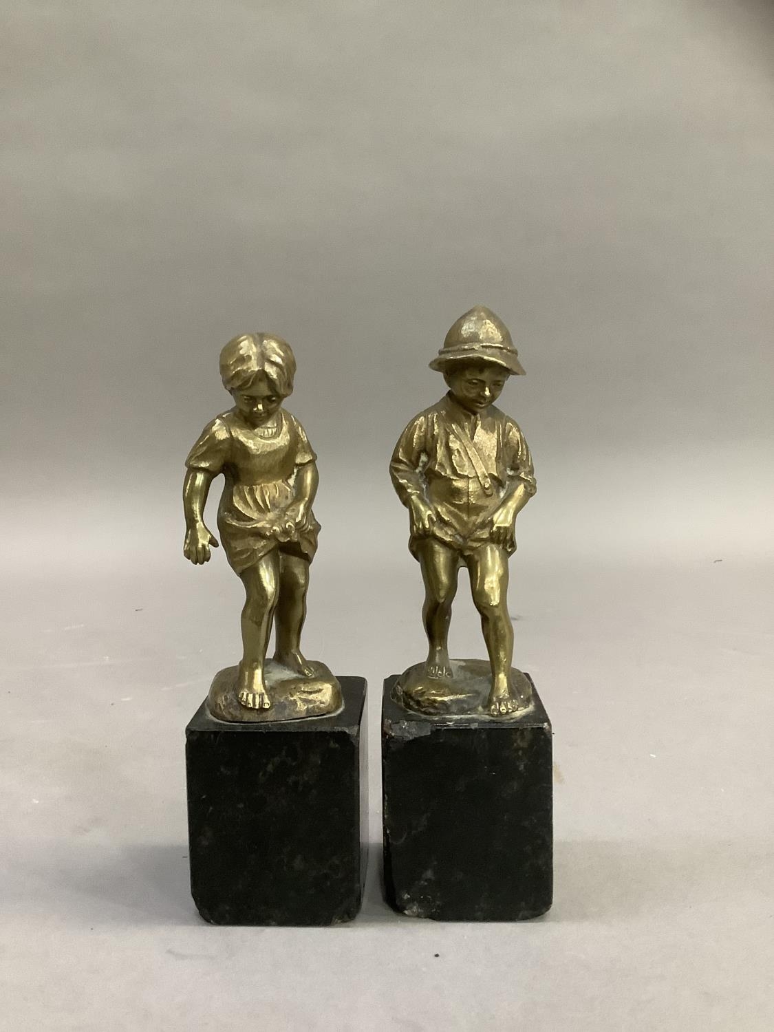 After Perot, a pair of 19th century brass sculptures of a boy and girl paddling raised on black