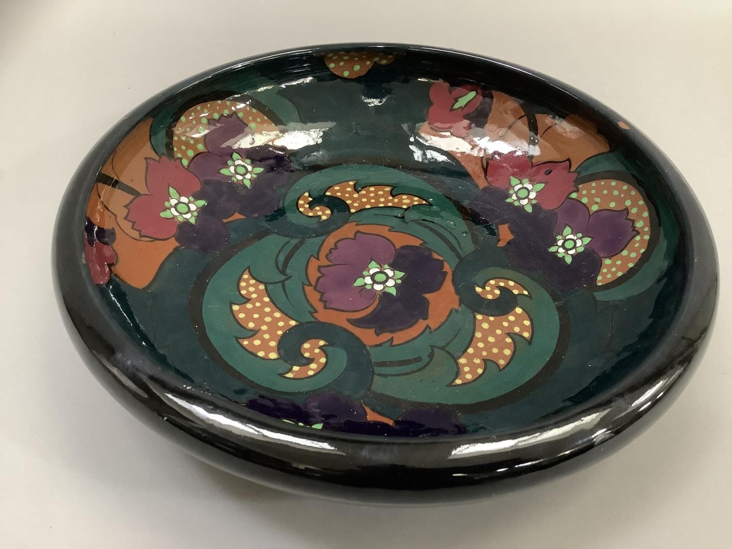 A twentieth century Art Deco glass bowl, the interior painted with purple flowers with foliage on an