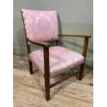 An early 20th century oak open armchair upholstered in pink damask