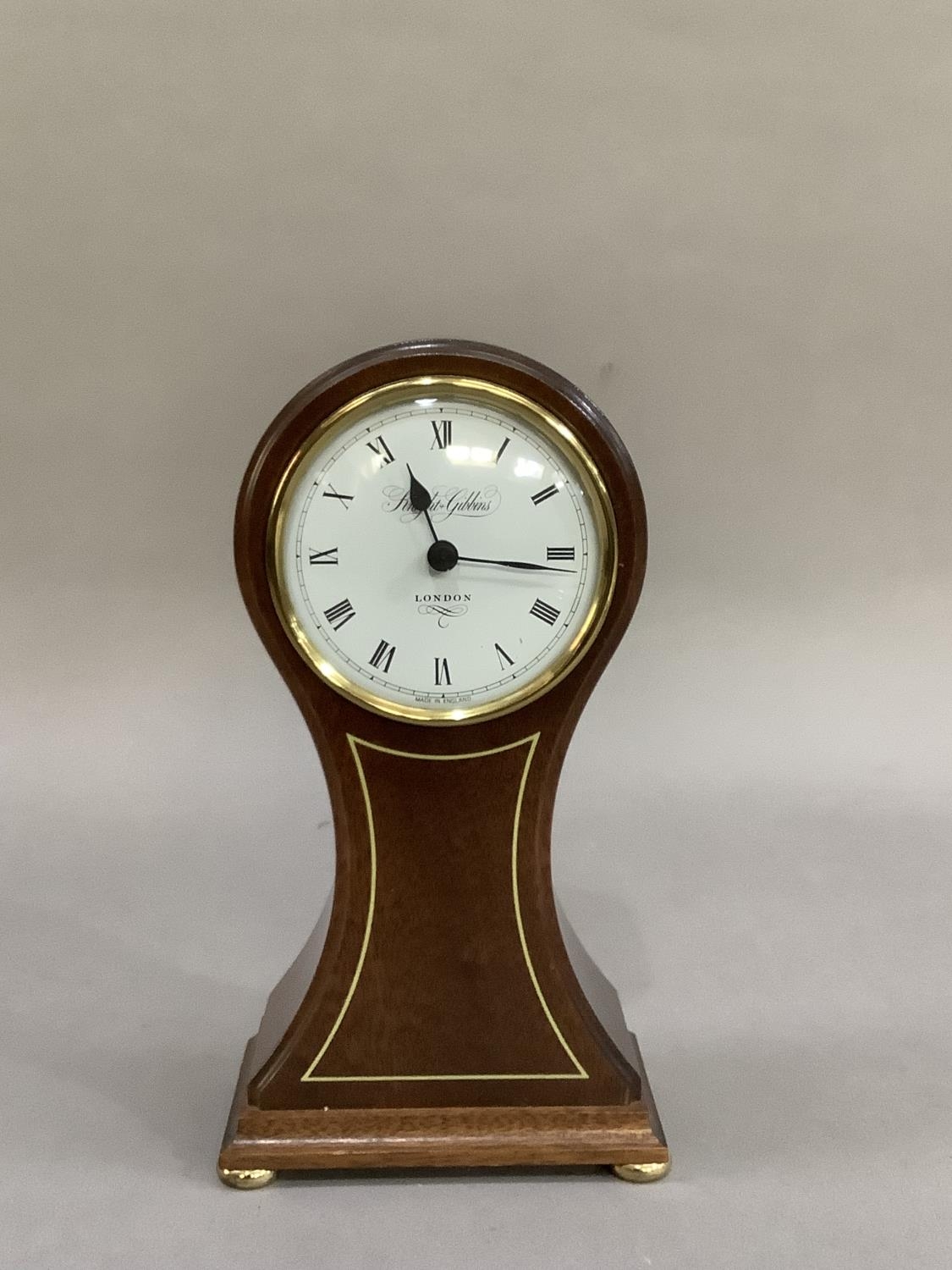 A reproduction, mahogany balloon clock having a white enamelled dial signed Knight and Gibbins,