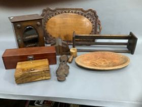 A 1920's oak smokers cabinet with oval glass panel to the door, a book trough, a bread dish carved