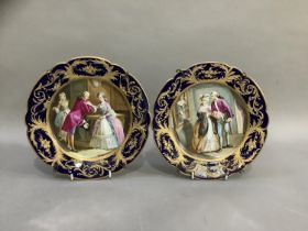 A pair of late 19th century 'Sevres' plates, painted with a couple, signed, within a gros bleu and