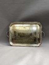 A large Edwardian silver plated two handled tray with egg and dart rim engraved to the centre with