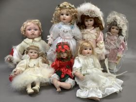 A collection of modern dolls, some on stands