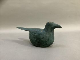 A naive carving of a bird finished in sea green, 28cm long x 12cm high