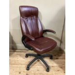 A swivel office chair in burgundy leather effect upholstery