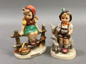 Two Hummel figures, girl on a fence with basket beside her and boy with goat and kid, 12cm and