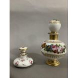 A continental scent bottle with bulbous body and globe stopper, hand painted with sprays of flower