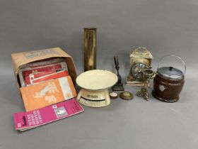 An onyx mantle clock, a WWI brass shell, a wooden biscuit barrel, a letter press, a brass table