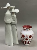 A large Lladro figure group of two nuns, 32cm high together with a Bohemian white glass, ruby